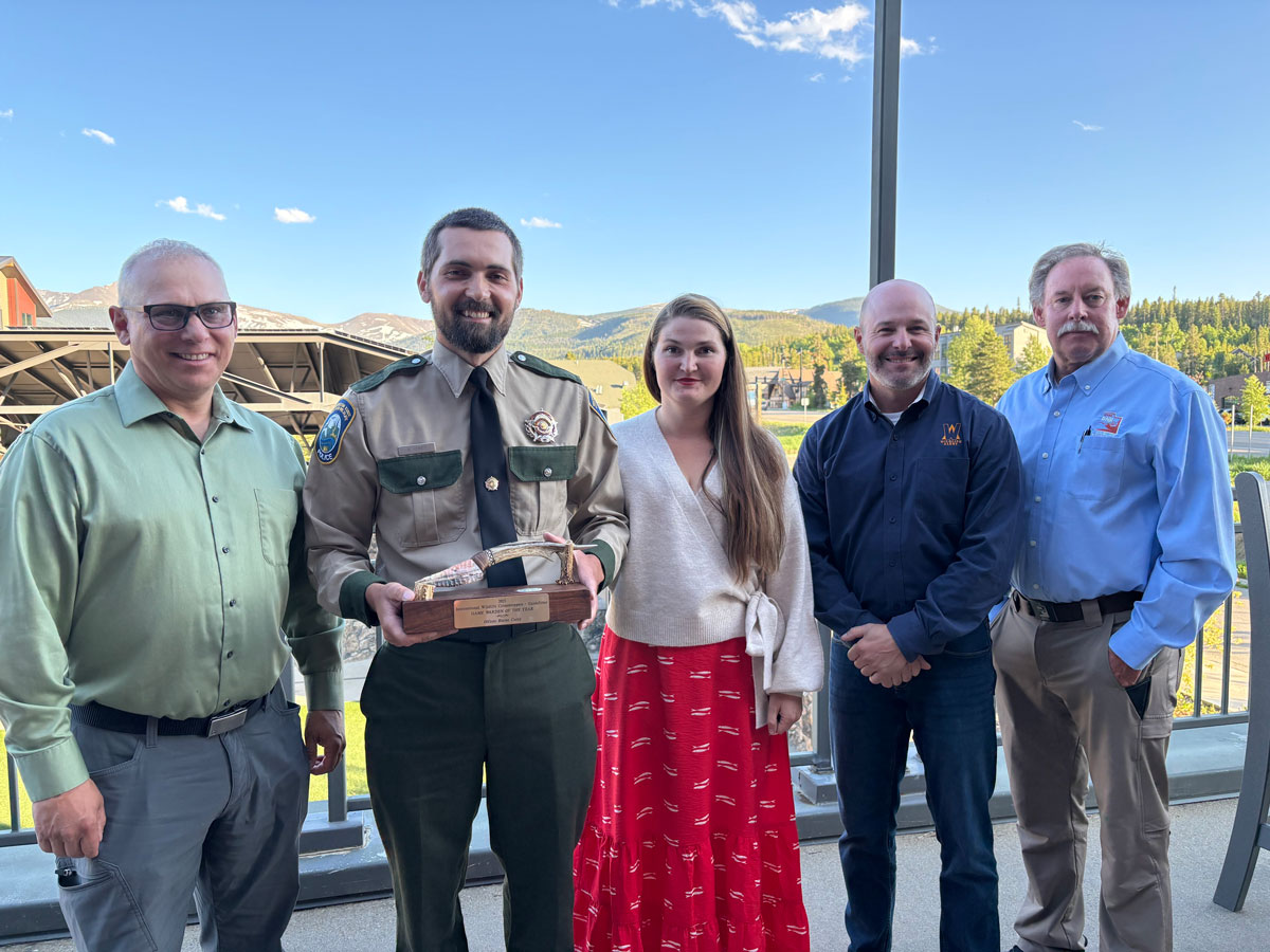 Washington Department of Fish and Wildlife Officer Blaine Corey, the 2025 Game Warden of the Year, poses with his award alongside his wife Theda and representatives from International Wildlife Crimestoppers.
