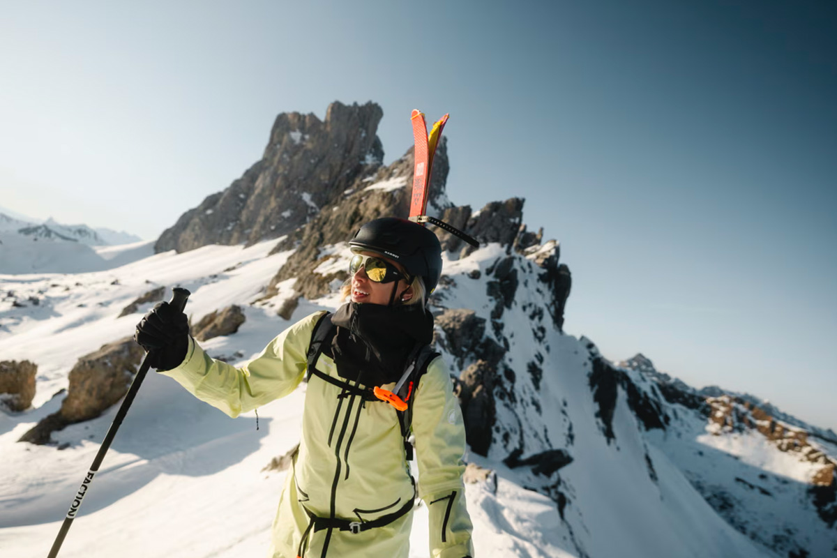 Freerider in Mammut weatherproof jacket skiing down untouched powder slopes in the Austrian mountains.